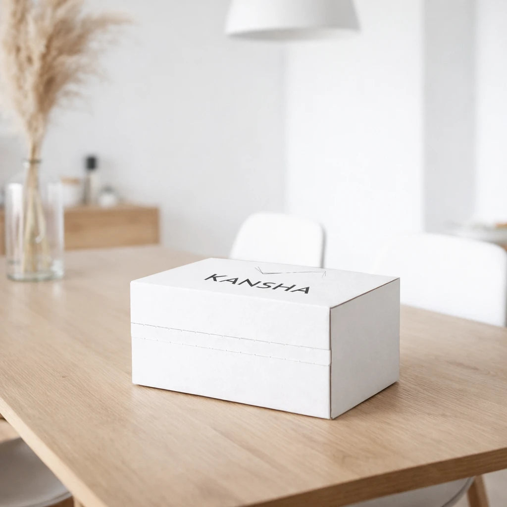 Packaging de livraison KANSHA posé sur une table en bois clair, illustrant l’expérience de réception soignée des compléments alimentaires KANSHA à domicile